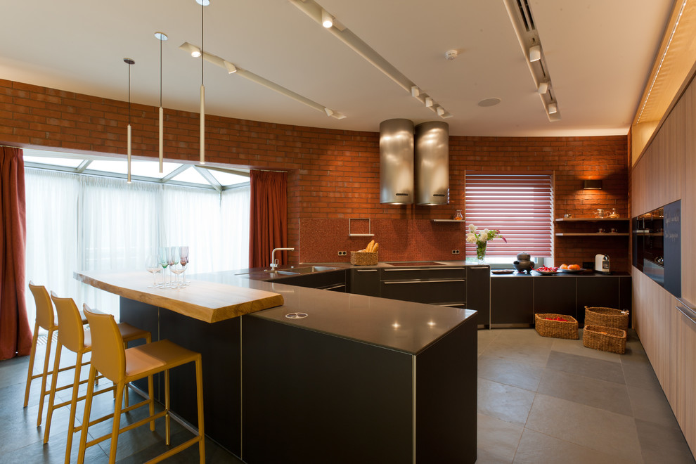 Стильный дизайн: п-образная кухня в современном стиле с обеденным столом, плоскими фасадами и черными фасадами - последний тренд
