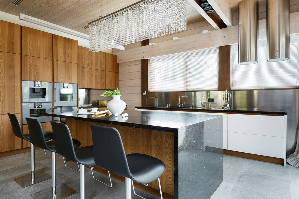 На фото: угловая кухня-гостиная в современном стиле с плоскими фасадами, фасадами цвета дерева среднего тона, фартуком цвета металлик, островом и цветной техникой с