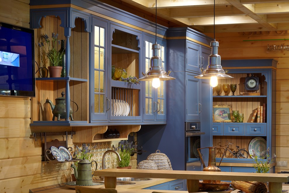 Imagen de cocina lineal de estilo de casa de campo de tamaño medio cerrada con armarios con paneles con relieve, puertas de armario azules, encimera de laminado y salpicadero beige