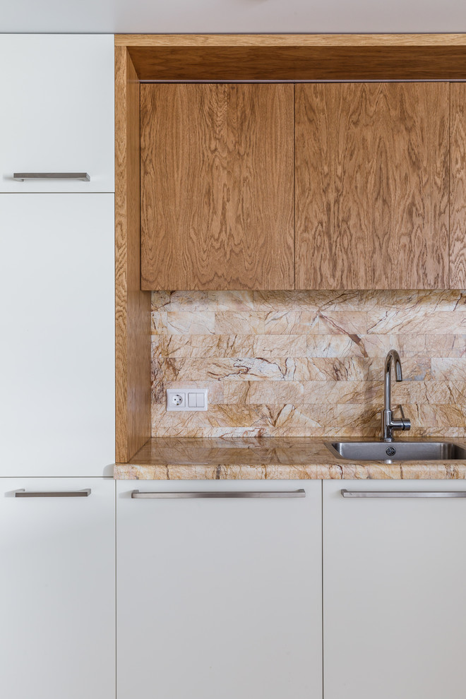 Foto di una cucina minimal con lavello da incasso, ante lisce, ante bianche, paraspruzzi beige e top beige