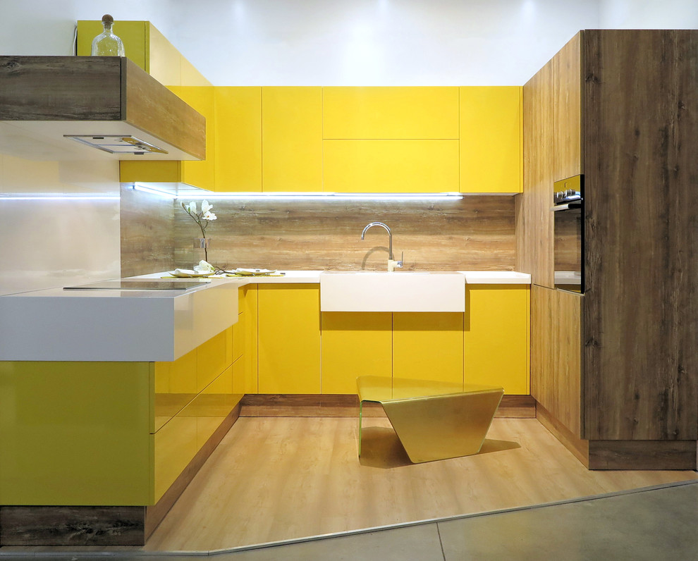Пример оригинального дизайна: п-образная кухня в современном стиле с плоскими фасадами, желтыми фасадами, бежевым фартуком и монолитной мойкой без острова