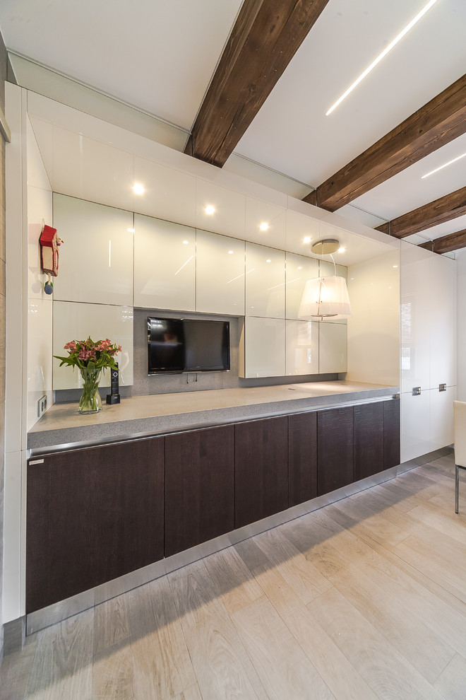 This is an example of a contemporary galley kitchen/diner in Moscow with flat-panel cabinets, light hardwood flooring, no island and beige floors.