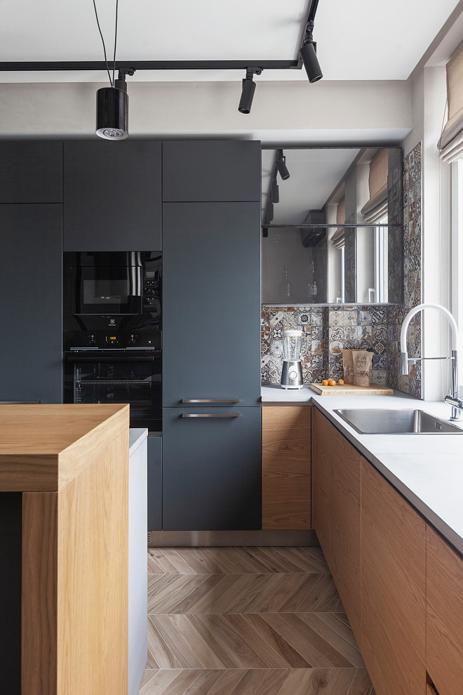 Immagine di una cucina contemporanea con lavello da incasso, ante lisce, ante in legno scuro, paraspruzzi multicolore, elettrodomestici neri, pavimento marrone e top bianco