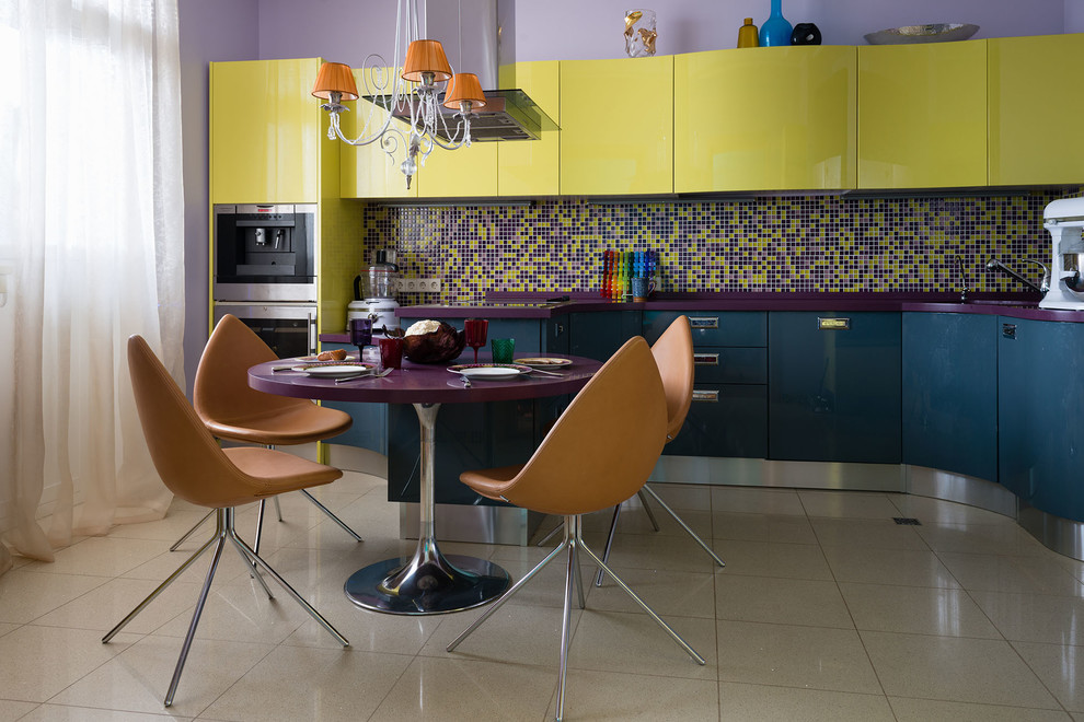 Источник вдохновения для домашнего уюта: угловая кухня среднего размера в современном стиле с обеденным столом, врезной мойкой, плоскими фасадами, желтыми фасадами, столешницей из акрилового камня, разноцветным фартуком, фартуком из плитки мозаики, техникой из нержавеющей стали, полом из керамогранита и полуостровом