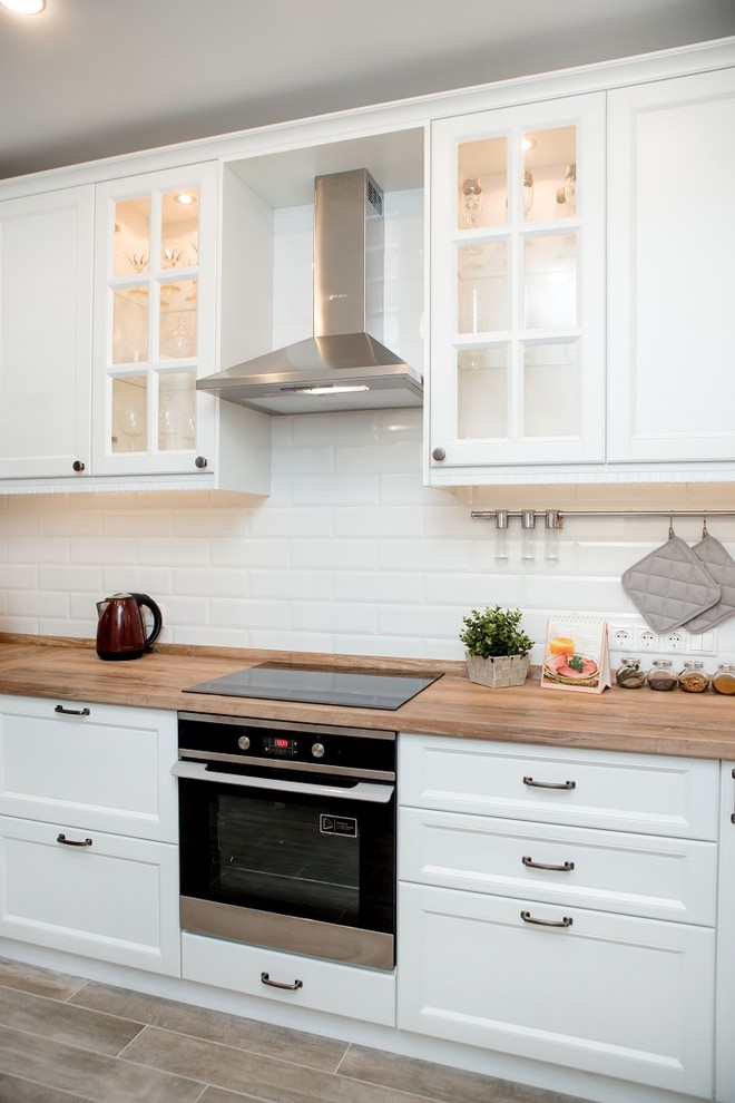 Imagen de cocinas en U escandinavo de tamaño medio con armarios con paneles empotrados y puertas de armario blancas