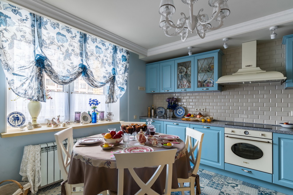 Klassische Wohnküche ohne Insel mit profilierten Schrankfronten, blauen Schränken, Küchenrückwand in Grau, Rückwand aus Metrofliesen, weißen Elektrogeräten, buntem Boden und grauer Arbeitsplatte in Sankt Petersburg