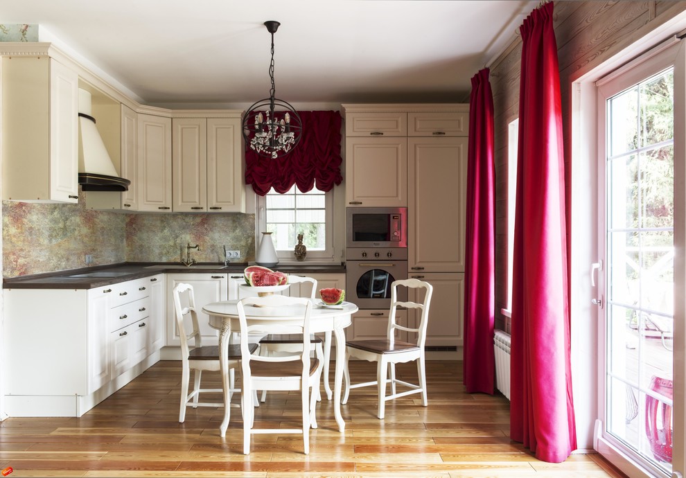 Exempel på ett mellanstort klassiskt kök, med luckor med upphöjd panel, träbänkskiva, flerfärgad stänkskydd, glaspanel som stänkskydd, rostfria vitvaror, mellanmörkt trägolv och vita skåp
