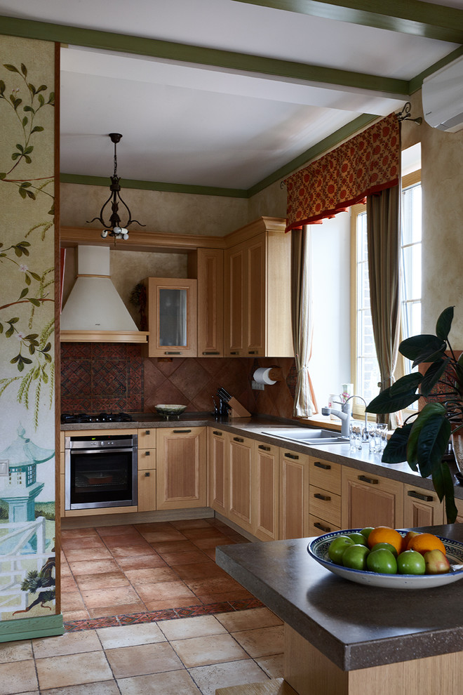 Foto di una cucina ad U country con ante in legno chiaro, paraspruzzi marrone, elettrodomestici in acciaio inossidabile, penisola e paraspruzzi a finestra