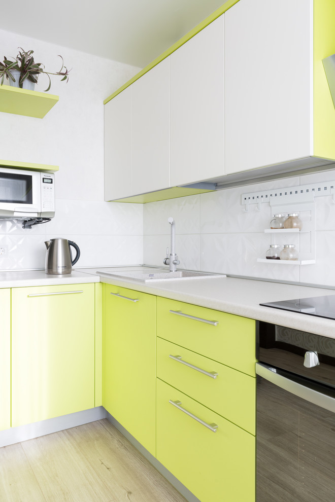 Foto på ett mellanstort funkis vit kök, med släta luckor, gröna skåp, vitt stänkskydd och beiget golv