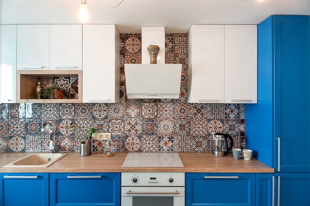 Eklektisk inredning av ett mellanstort linjärt kök och matrum, med en nedsänkt diskho, luckor med infälld panel, blå skåp, laminatbänkskiva, stänkskydd i keramik, vita vitvaror, laminatgolv, en köksö och beiget golv