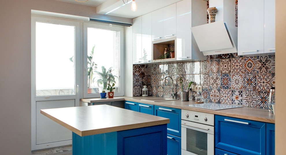 Immagine di una cucina eclettica di medie dimensioni con lavello da incasso, ante con riquadro incassato, ante blu, top in laminato, paraspruzzi con piastrelle in ceramica, elettrodomestici bianchi, pavimento in laminato e pavimento beige