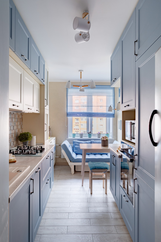 This is an example of a small contemporary galley kitchen/diner in Moscow with recessed-panel cabinets, blue cabinets, no island, beige floors, beige worktops and multi-coloured splashback.