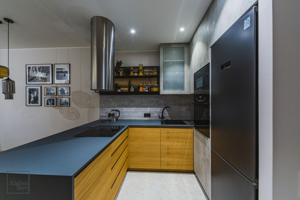 Идея дизайна: п-образная кухня-гостиная среднего размера в стиле лофт с накладной мойкой, плоскими фасадами, серыми фасадами, черной техникой и полуостровом