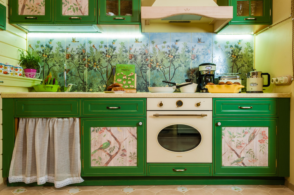Einzeilige, Kleine Eklektische Wohnküche mit profilierten Schrankfronten, grünen Schränken, Mineralwerkstoff-Arbeitsplatte, Rückwand aus Keramikfliesen, bunten Elektrogeräten und Porzellan-Bodenfliesen in Moskau