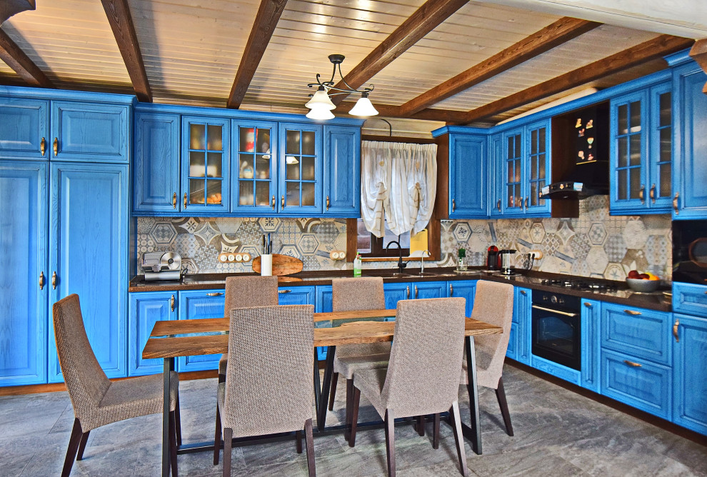 Bild på ett mellanstort rustikt brun brunt kök, med en integrerad diskho, luckor med upphöjd panel, blå skåp, bänkskiva i koppar, flerfärgad stänkskydd, stänkskydd i porslinskakel, svarta vitvaror, klinkergolv i porslin och grått golv