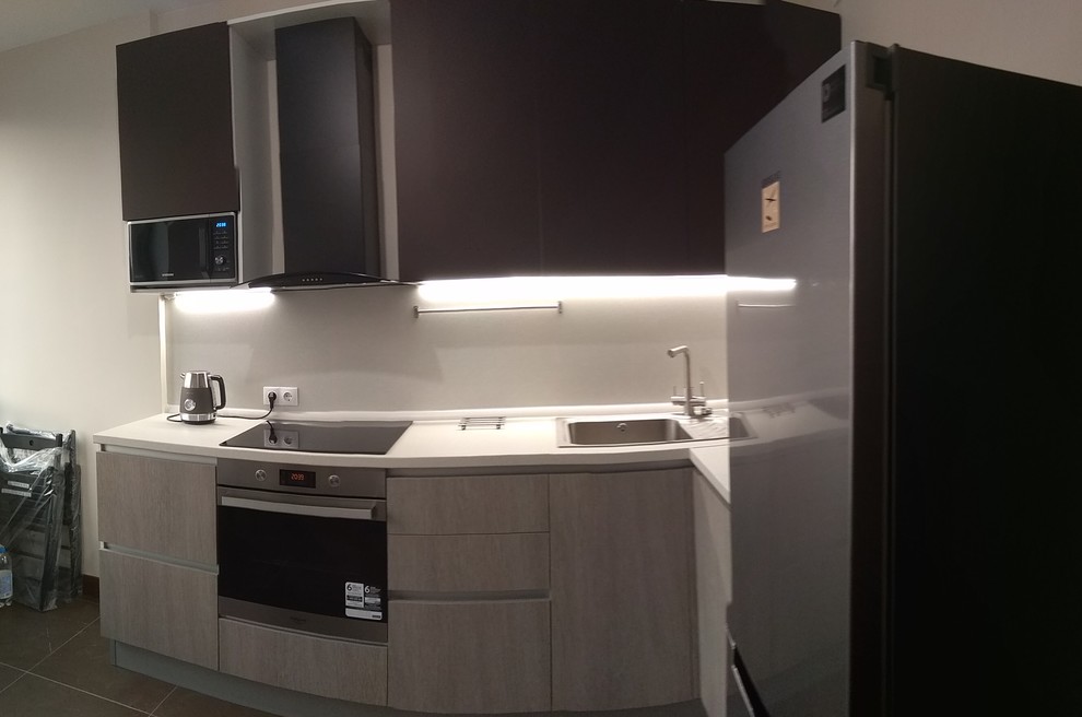 Example of a small l-shaped porcelain tile and brown floor enclosed kitchen design in Moscow with an undermount sink, flat-panel cabinets, medium tone wood cabinets, laminate countertops, beige backsplash, wood backsplash, black appliances, no island and beige countertops
