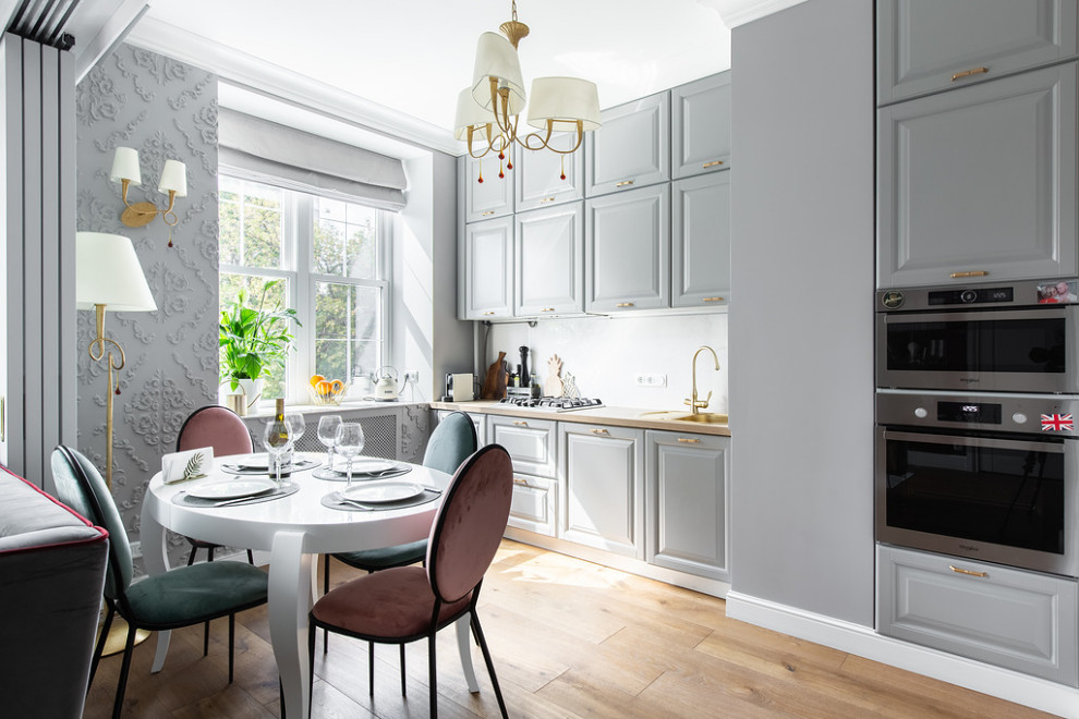 Inspiration for a medium sized traditional single-wall kitchen/diner with a submerged sink, recessed-panel cabinets, grey cabinets, wood worktops, white splashback, porcelain splashback, stainless steel appliances, medium hardwood flooring, no island and beige worktops.