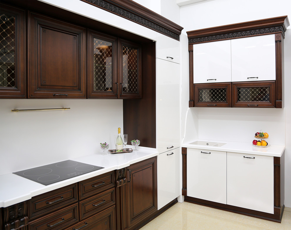 Inredning av ett klassiskt vit vitt kök, med en dubbel diskho, skåp i mörkt trä, bänkskiva i koppar och vitt stänkskydd