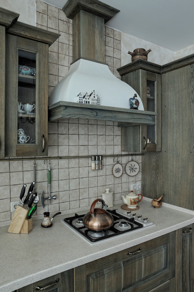 Foto di una cucina country con ante con bugna sagomata, ante in legno scuro, paraspruzzi grigio e top grigio