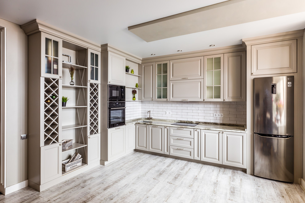 Пример оригинального дизайна: угловая кухня со шкафом над холодильником в стиле неоклассика (современная классика) с врезной мойкой, фасадами с выступающей филенкой, бежевыми фасадами, белым фартуком и черной техникой без острова