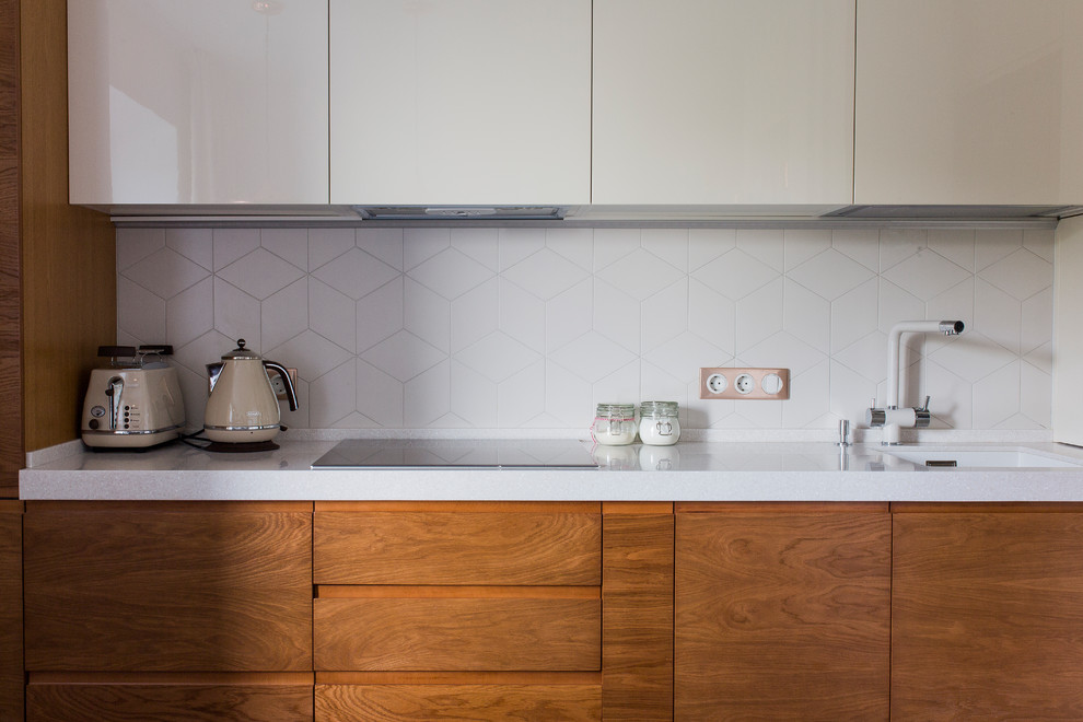 Foto di una cucina lineare design con lavello sottopiano, ante lisce, ante bianche e paraspruzzi bianco