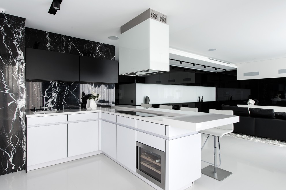 Свежая идея для дизайна: п-образная кухня-гостиная в современном стиле с врезной мойкой, плоскими фасадами, черным фартуком, техникой из нержавеющей стали и полуостровом - отличное фото интерьера