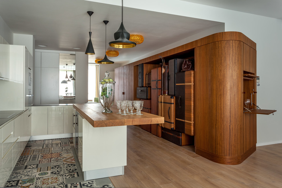 Diseño de cocina actual con armarios con paneles lisos, puertas de armario blancas, una isla y suelo multicolor