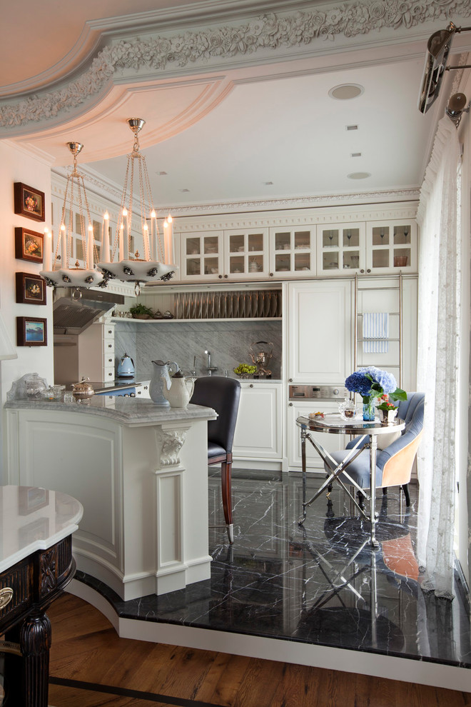 Пример оригинального дизайна: п-образная кухня в стиле неоклассика (современная классика) с фасадами с выступающей филенкой, белыми фасадами, серым фартуком, полуостровом и черным полом