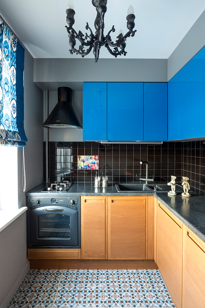 Esempio di una cucina a L design con lavello da incasso, ante lisce, ante in legno chiaro, paraspruzzi nero, elettrodomestici neri e nessuna isola