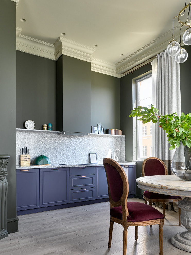 Classic single-wall open plan kitchen in Moscow with blue cabinets, grey splashback, light hardwood flooring, no island, beige floors and grey worktops.