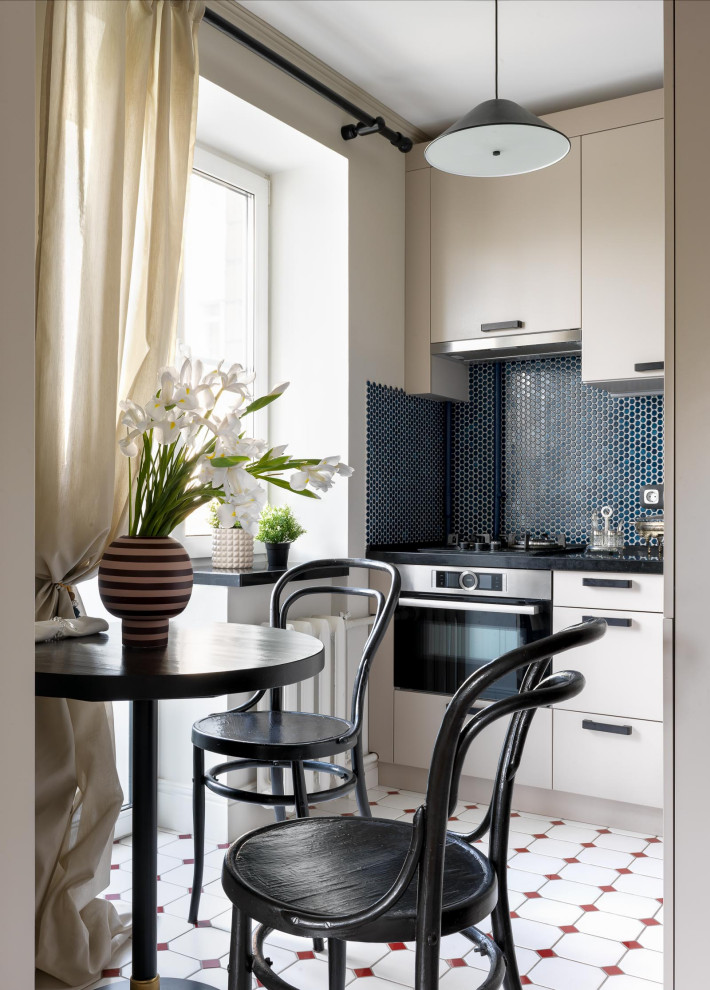 Photo of a small contemporary l-shaped kitchen/diner in Moscow with a submerged sink, engineered stone countertops, blue splashback, mosaic tiled splashback, stainless steel appliances, ceramic flooring, no island, white floors, black worktops, flat-panel cabinets and beige cabinets.