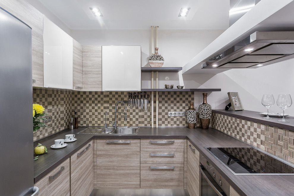 Inspiration for a small contemporary u-shaped open plan kitchen in Moscow with a double-bowl sink, flat-panel cabinets, stainless steel appliances, porcelain flooring, a breakfast bar, beige splashback, light wood cabinets and wood worktops.