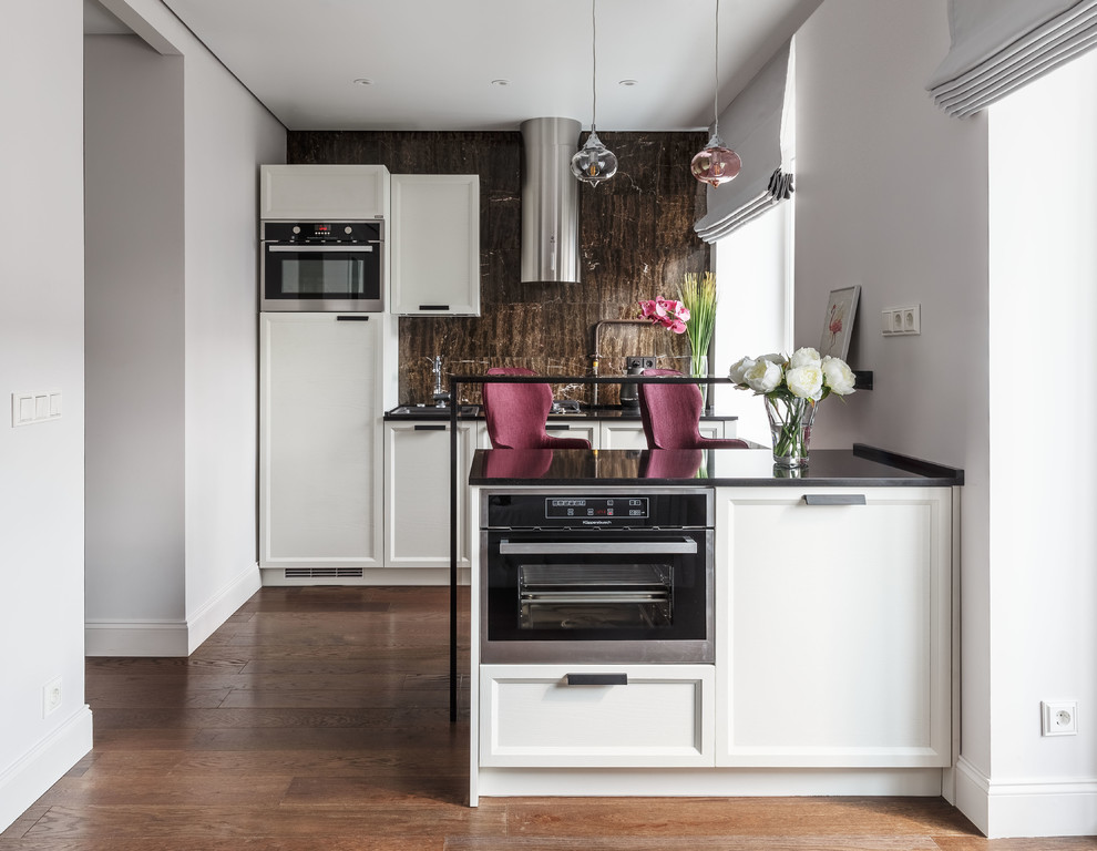 Contemporary galley open plan kitchen in Moscow with a built-in sink, recessed-panel cabinets, white cabinets, brown splashback, stainless steel appliances, medium hardwood flooring, a breakfast bar and brown floors.