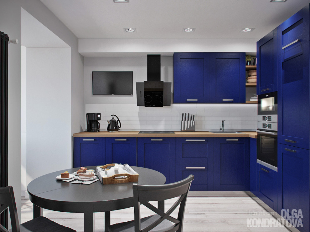 Идея дизайна: кухня в современном стиле с синими фасадами, белым фартуком, фартуком из плитки кабанчик и полом из керамогранита