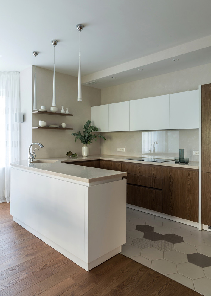 Пример оригинального дизайна: п-образная кухня-гостиная среднего размера в современном стиле с монолитной мойкой, плоскими фасадами, бежевым фартуком, полуостровом и мойкой в углу