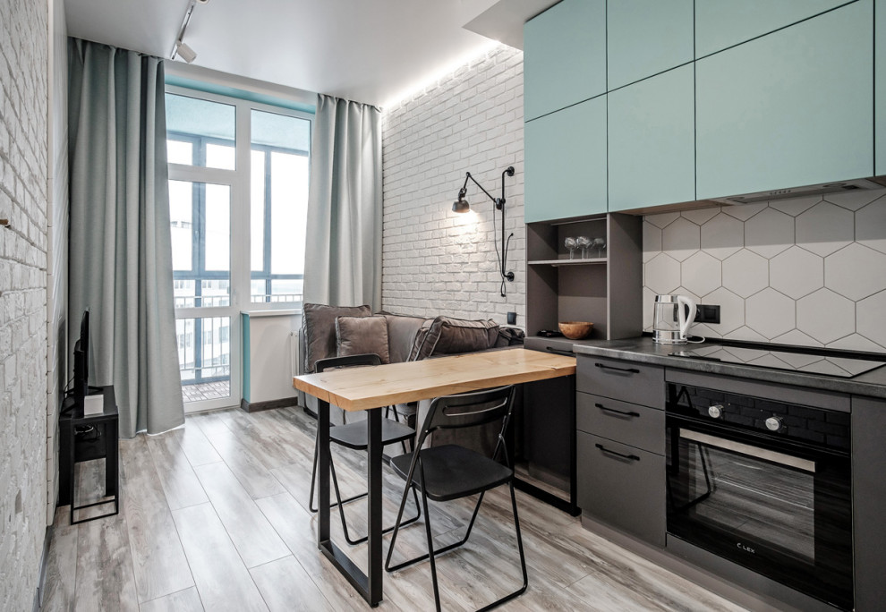 Open concept kitchen - scandinavian single-wall gray floor open concept kitchen idea in Yekaterinburg with flat-panel cabinets, turquoise cabinets, white backsplash, black appliances, no island and black countertops