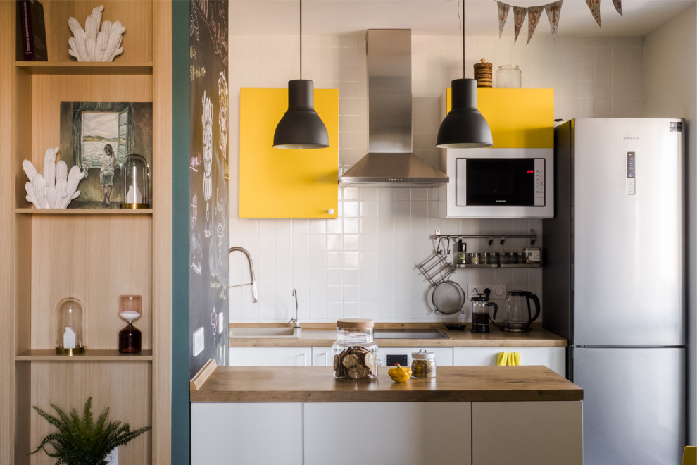 Moderne Küche mit Einbauwaschbecken, flächenbündigen Schrankfronten, gelben Schränken, Küchenrückwand in Weiß, weißen Elektrogeräten, Halbinsel und brauner Arbeitsplatte in Moskau