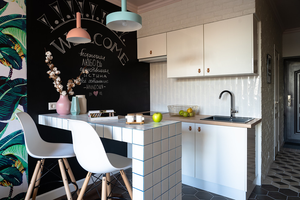 Inspiration for a world-inspired open plan kitchen in Saint Petersburg with a built-in sink, flat-panel cabinets, white cabinets, white splashback, beige worktops, wood worktops, a breakfast bar and multi-coloured floors.