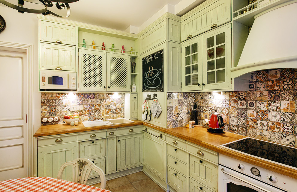 Cottage l-shaped brown floor enclosed kitchen photo in Moscow with a drop-in sink, green cabinets, multicolored backsplash, white appliances and no island