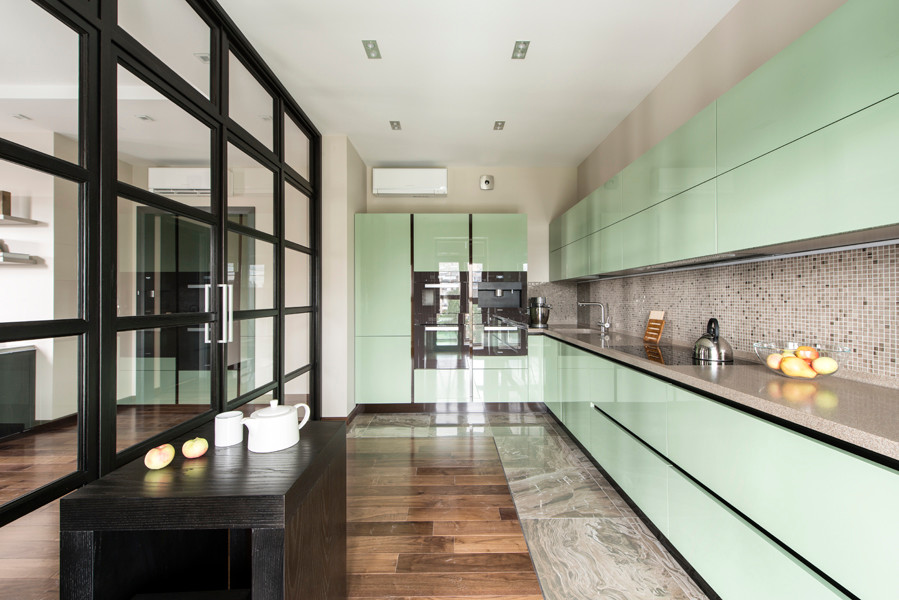 На фото: кухня в современном стиле с плоскими фасадами, зелеными фасадами, бежевым фартуком и фартуком из плитки мозаики