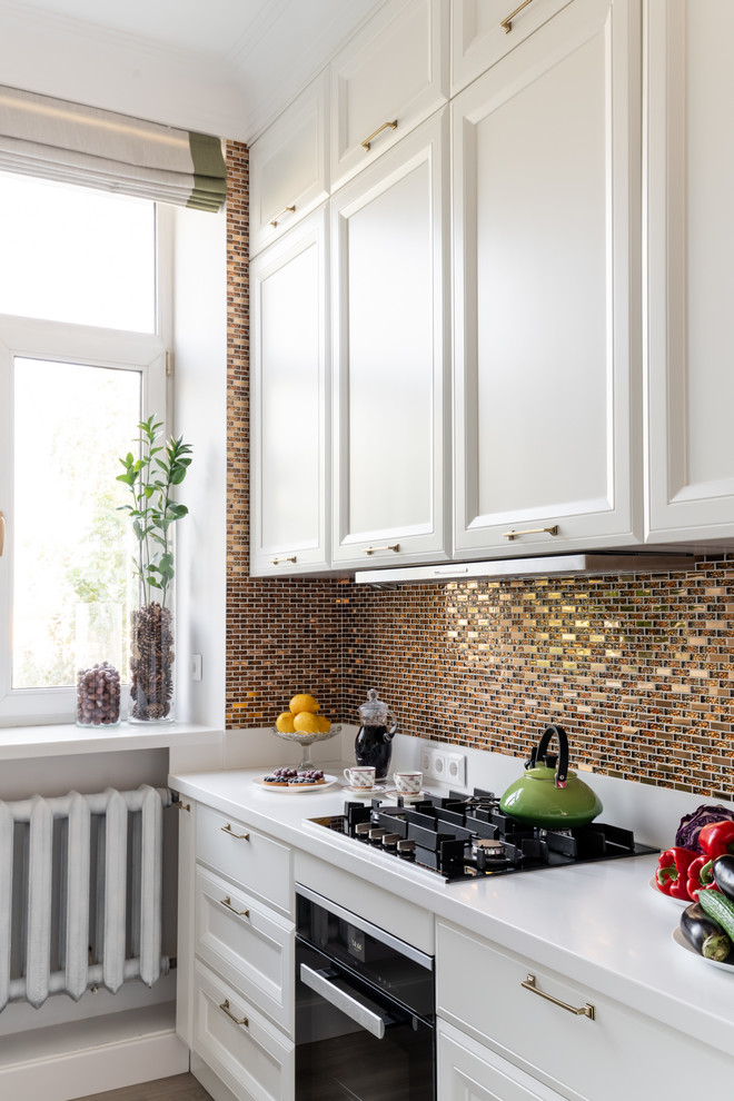 Inspiration for a medium sized traditional l-shaped enclosed kitchen in Moscow with a submerged sink, raised-panel cabinets, white cabinets, composite countertops, yellow splashback, mosaic tiled splashback, stainless steel appliances, laminate floors, beige floors and white worktops.