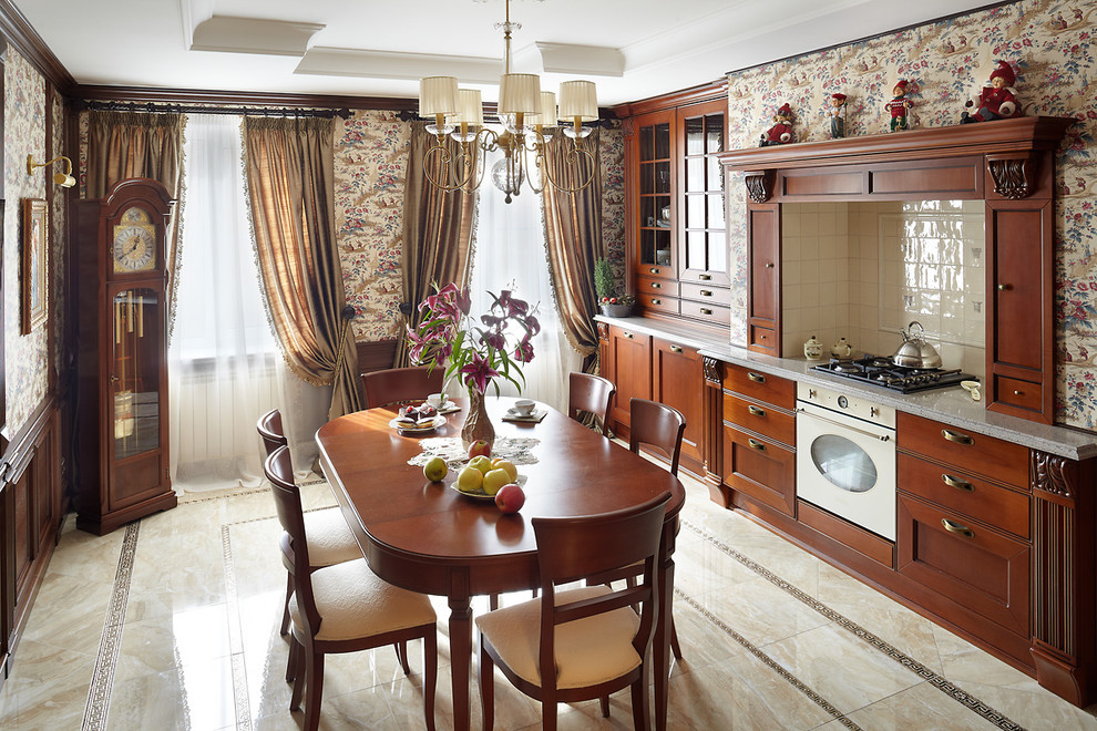 Пример оригинального дизайна: прямая кухня со стиральной машиной в классическом стиле с обеденным столом, фасадами с утопленной филенкой, фасадами цвета дерева среднего тона, белым фартуком и белой техникой