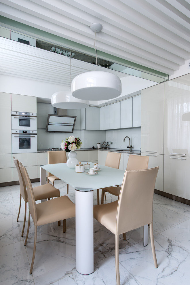 Idéer för att renovera ett mellanstort funkis grå grått kök, med en undermonterad diskho, släta luckor, grå skåp, granitbänkskiva, vitt stänkskydd, glaspanel som stänkskydd, vita vitvaror, klinkergolv i keramik och vitt golv