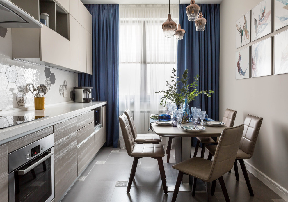 Свежая идея для дизайна: прямая кухня в скандинавском стиле с плоскими фасадами, техникой из нержавеющей стали, серым полом и белой столешницей - отличное фото интерьера