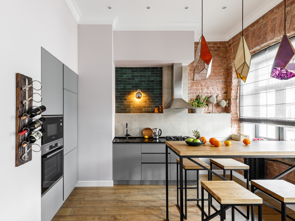 Свежая идея для дизайна: кухня среднего размера в стиле лофт с обеденным столом, врезной мойкой, серыми фасадами и фартуком из керамической плитки - отличное фото интерьера