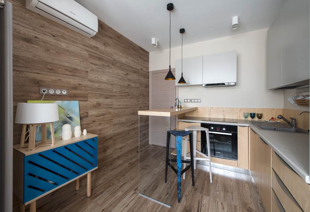 Moderne Küche in L-Form mit Einbauwaschbecken, flächenbündigen Schrankfronten, schwarzen Elektrogeräten, braunem Holzboden, Halbinsel und hellen Holzschränken in Moskau