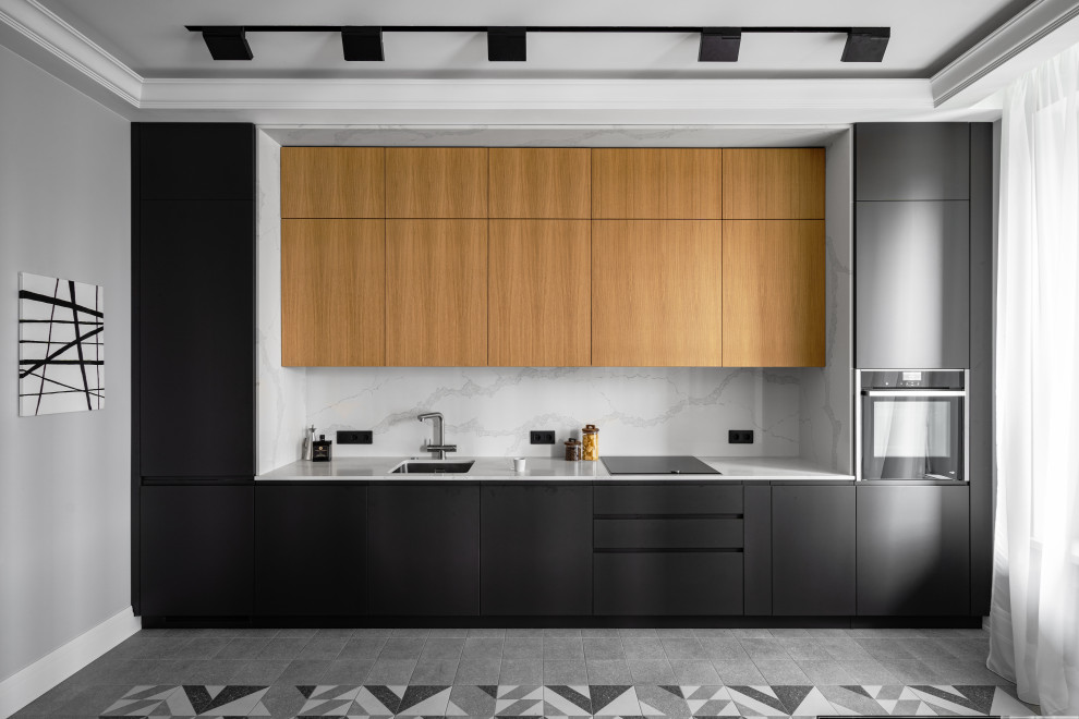 Bild på ett mellanstort funkis vit linjärt vitt kök och matrum, med en undermonterad diskho, släta luckor, skåp i mellenmörkt trä, bänkskiva i kvarts, vitt stänkskydd, svarta vitvaror, klinkergolv i keramik och grått golv