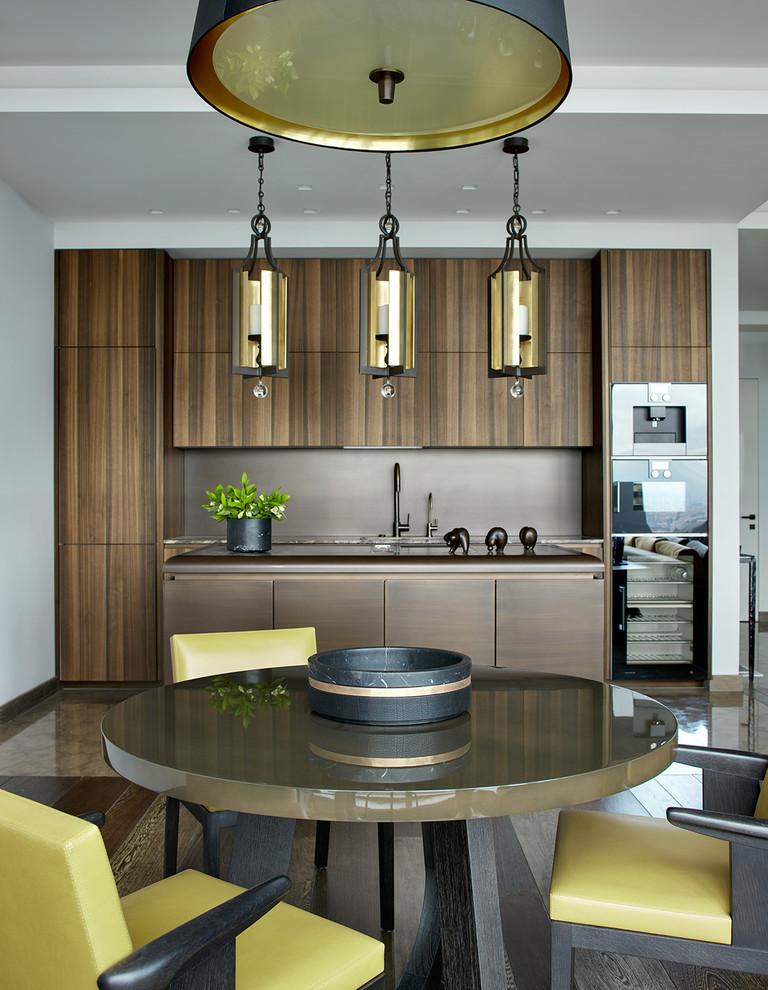 Свежая идея для дизайна: кухня в современном стиле с плоскими фасадами, коричневым фартуком, черной техникой, островом, обеденным столом и темными деревянными фасадами - отличное фото интерьера