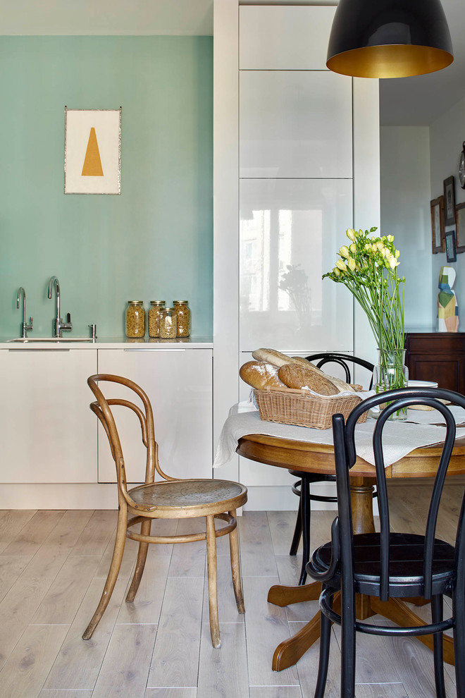 Inspiration för ett minimalistiskt kök, med en undermonterad diskho, släta luckor, vita skåp, ljust trägolv och beiget golv