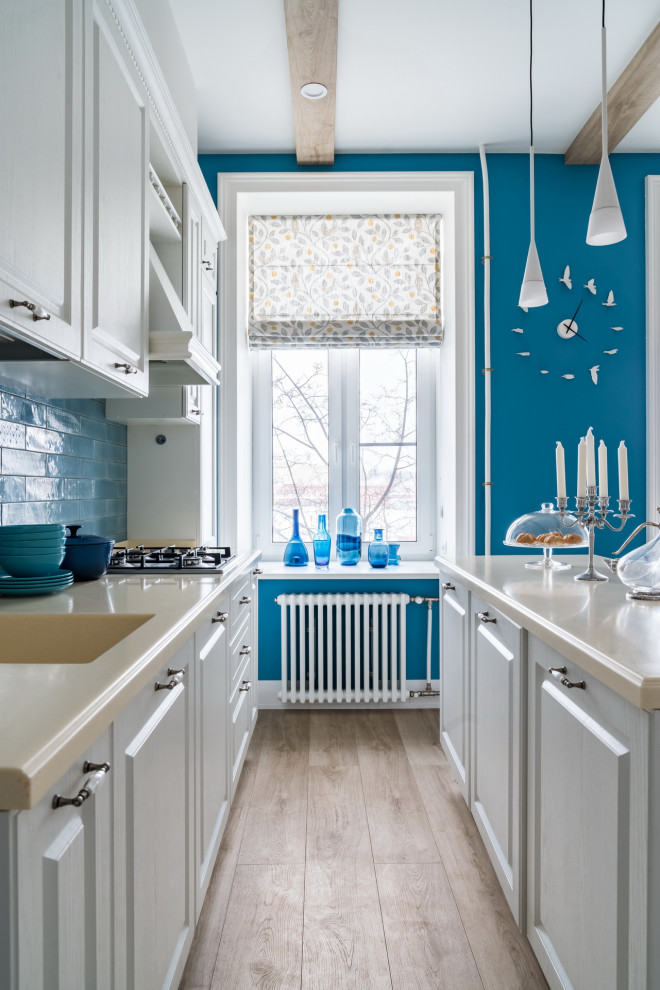 Immagine di una cucina tradizionale di medie dimensioni con lavello integrato, ante con bugna sagomata, ante grigie, paraspruzzi blu, elettrodomestici da incasso, pavimento beige e top beige